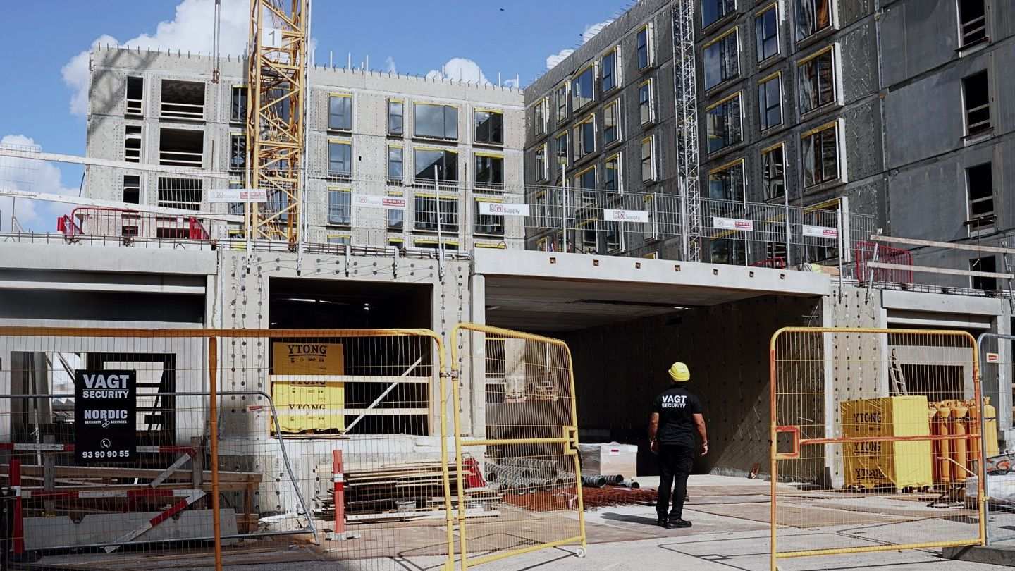 Vagt fra Nordic Security på en byggeplads med byggehegn