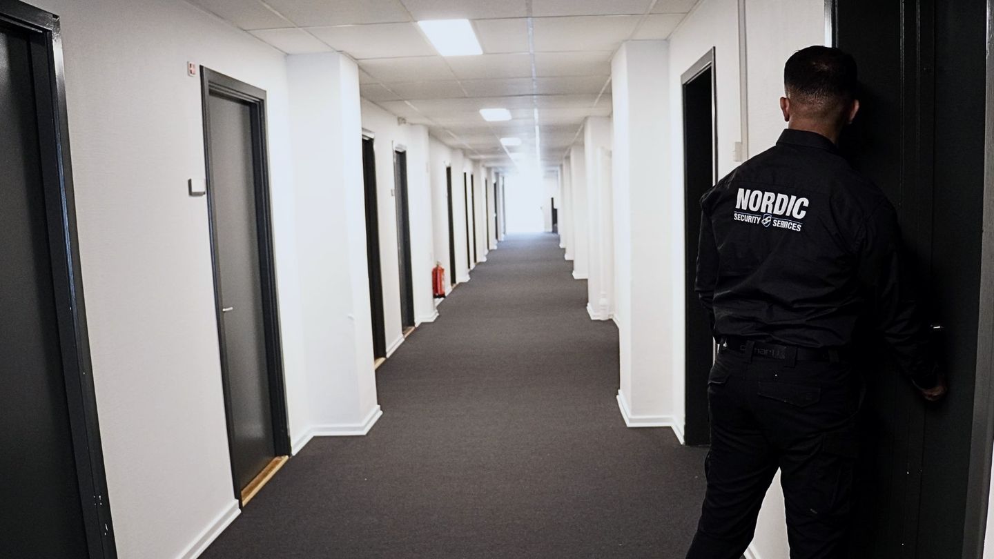Vagt fra Nordic Security med NORDIC på ryggen i en gang